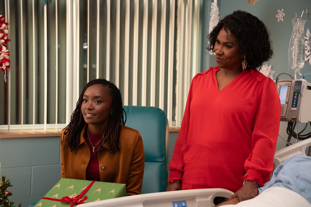 Maya and Eleanor smiling next to Keenan's bed in the hospital room