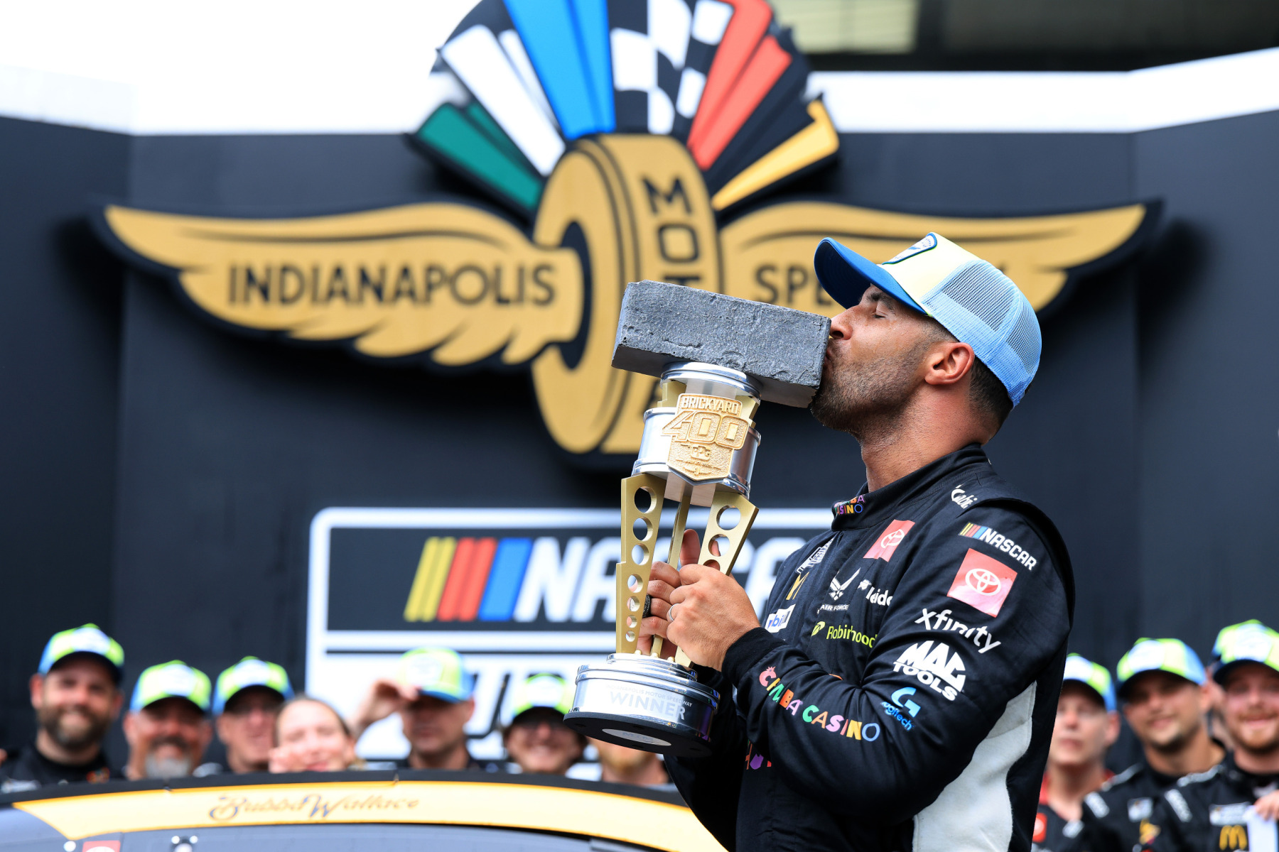 Bubba Wallace, driver of the #23 Chumba Casino Toyota, kisses the Brickyard 400 trophy in victory lane.
