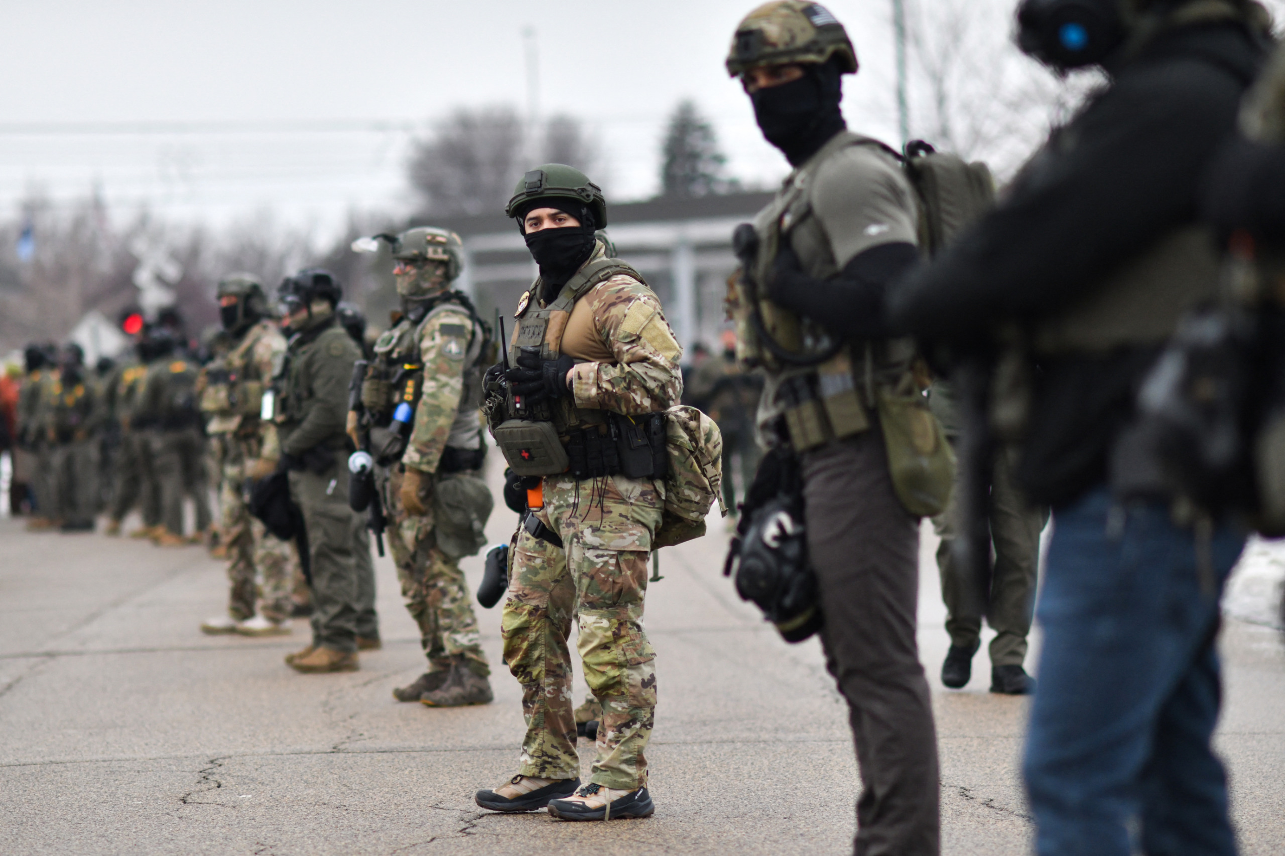 Federal agents stand guard as protestors gather.