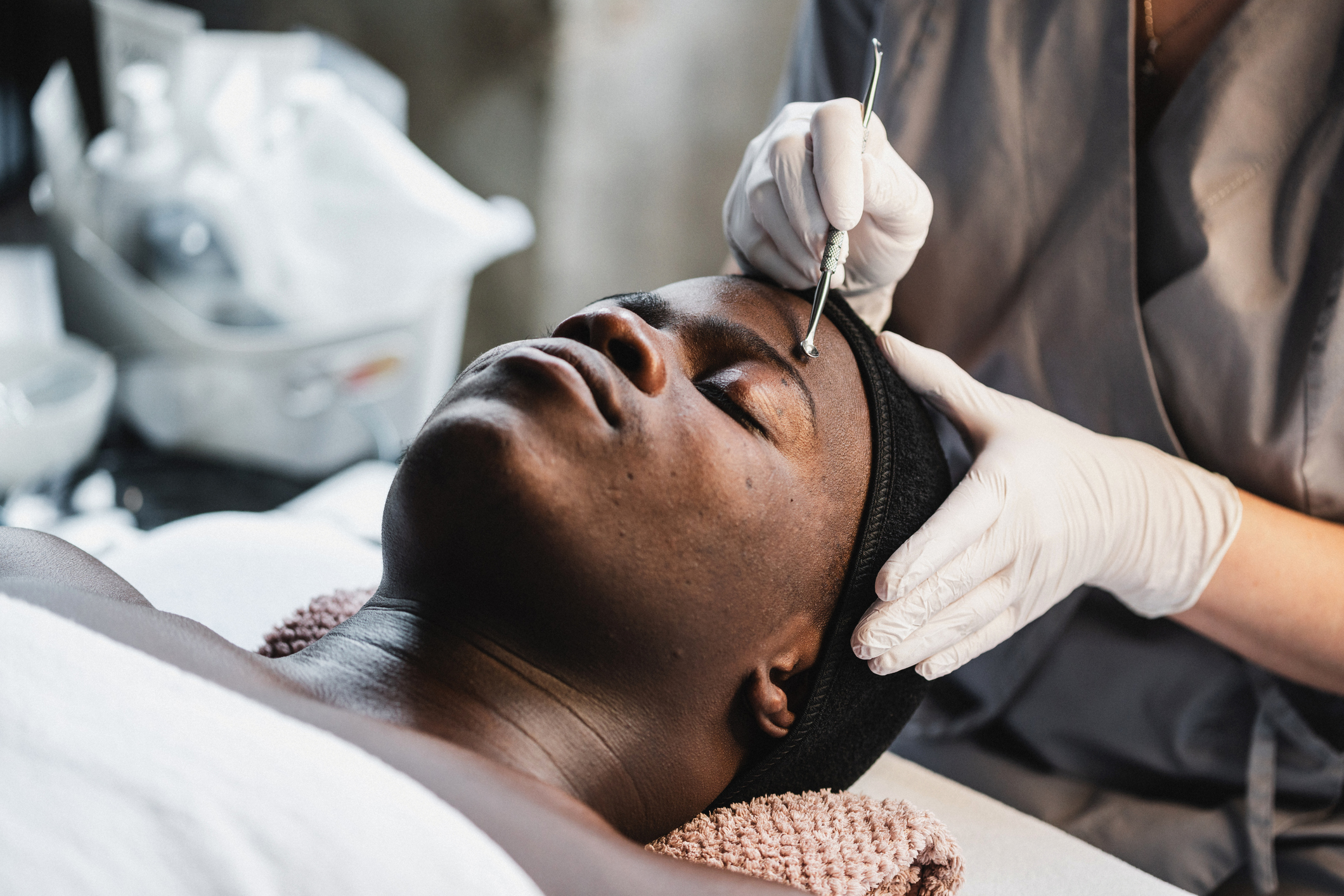 Men's skincare: facial treatments at the spa. Young black man getting face skin cleaning in spa salon