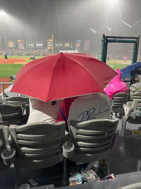 A couple enjoys the World Baseball Classic despite the rain.