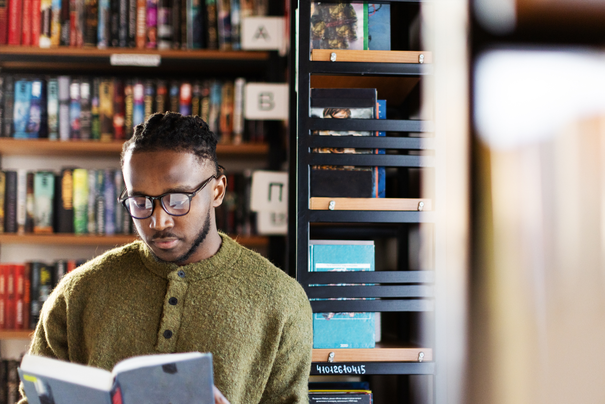 Adult student with a book in library